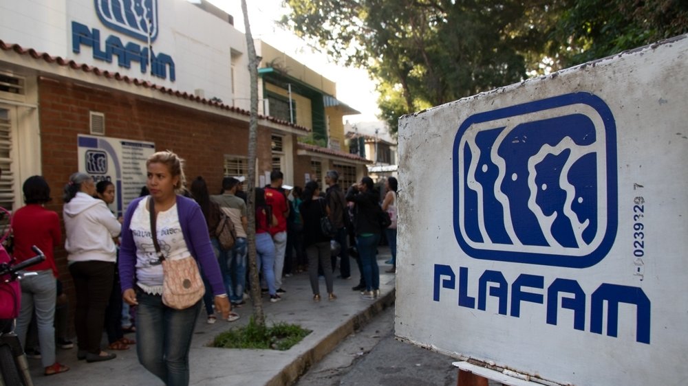 People wait in line outside PLAFAM facility.