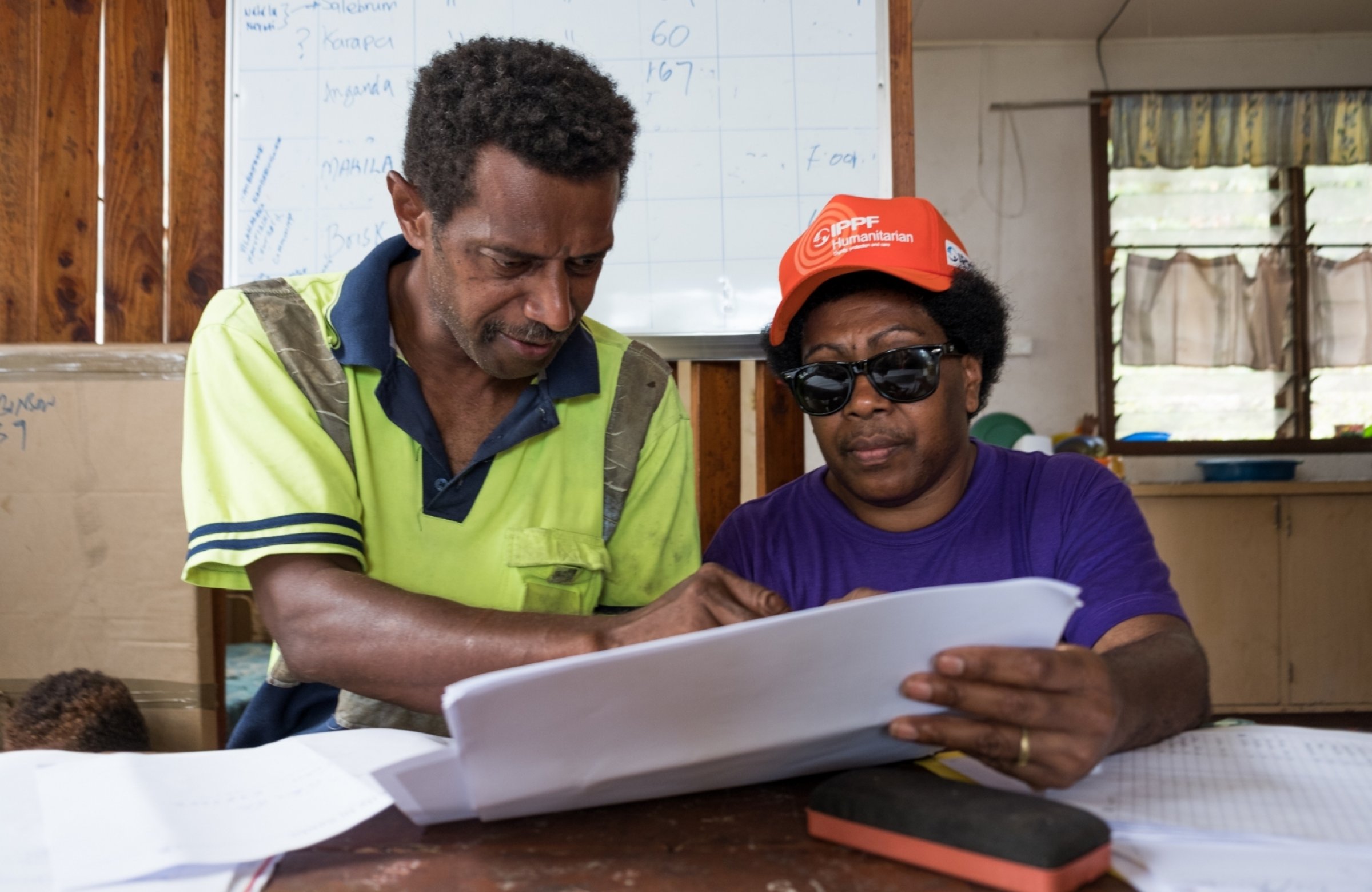 Two people review a piece of paper together.