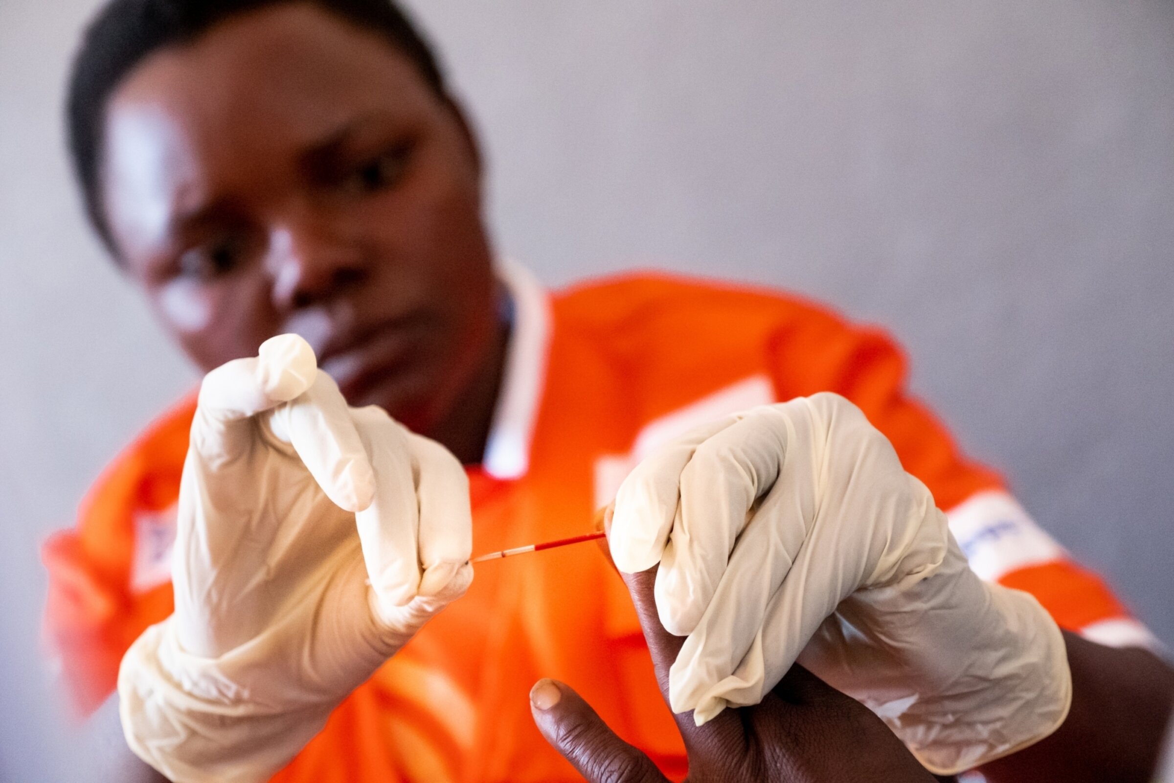 Nurse takes a blood prick from someone's finger.