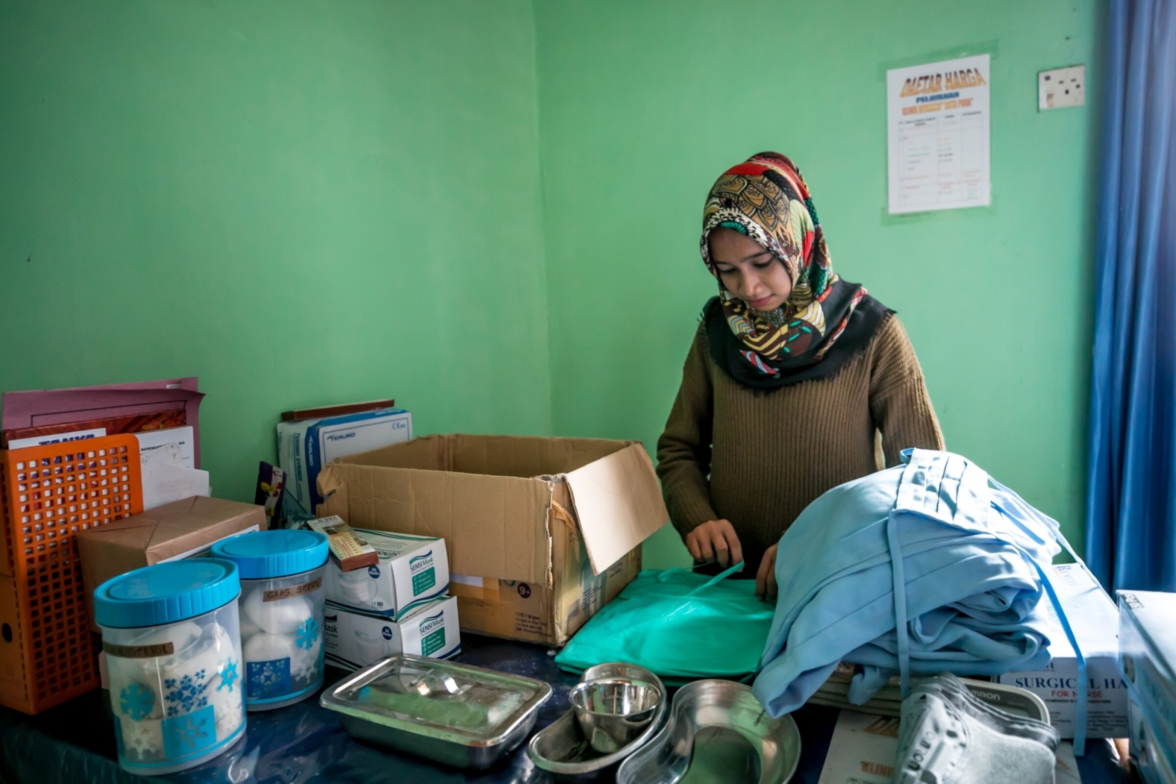 Woman unpacks a box of supplies.