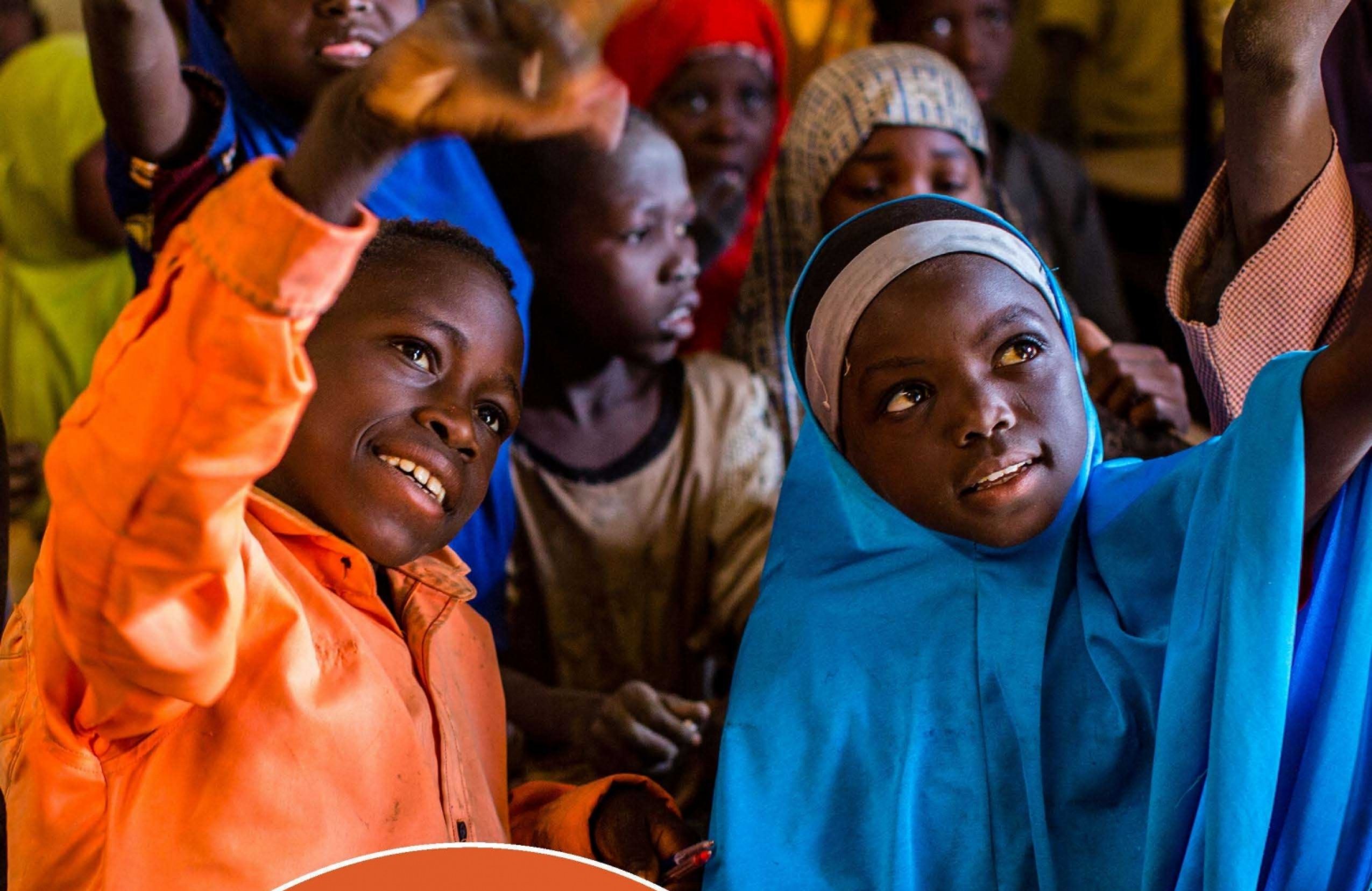 A group of children raising their hands.