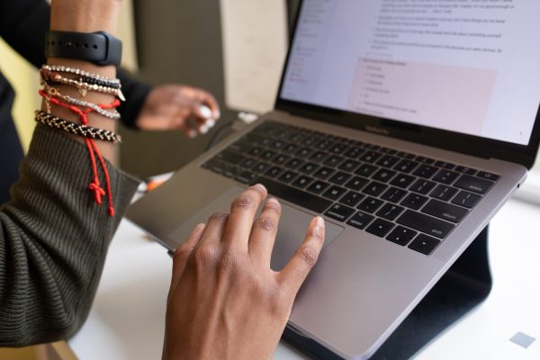 Hands on a trackpad of a laptop.